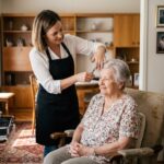 Coiffeuse à domicile coiffant une femme âgée dans son salon, service de coiffure senior à domicile